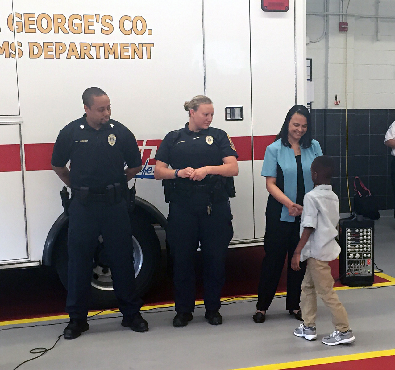 Dahmari Jenkins shakes hands with the dispatcher and Seat Pleasant officers who helped him. (WTOP/Megan Cloherty)