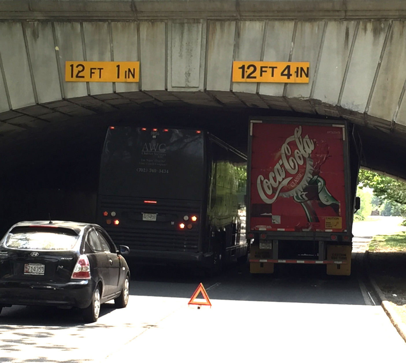 Two vehicles try to pass a stuck truck wedged below  the Memorial Bridge along the George Washington Memorial Parkway Tuesday. (WTOP/Jim Battagliese)