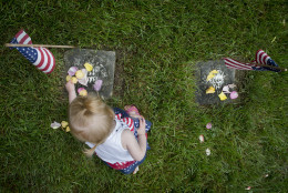Brielle Nathon, of Lebanon, Ohio, places rose petals on the gravestone of a soldier who died in the Civil War, Monday, May 25, 2015, at Spring Grove Cemetery in Cincinnati. The cemetery is the final resting place of thousands of Civil War soldiers, both Union and Confederate. (AP Photo/John Minchillo)