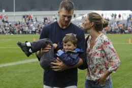 New England Patriots quarterback Tom Brady and his wife Gisele Bundchen with their son Benjamin Brady after a joint workout with the Tampa Bay Buccaneers at NFL football training camp, in Foxborough, Mass., Tuesday, Aug. 13, 2013. (AP Photo/Charles Krupa)