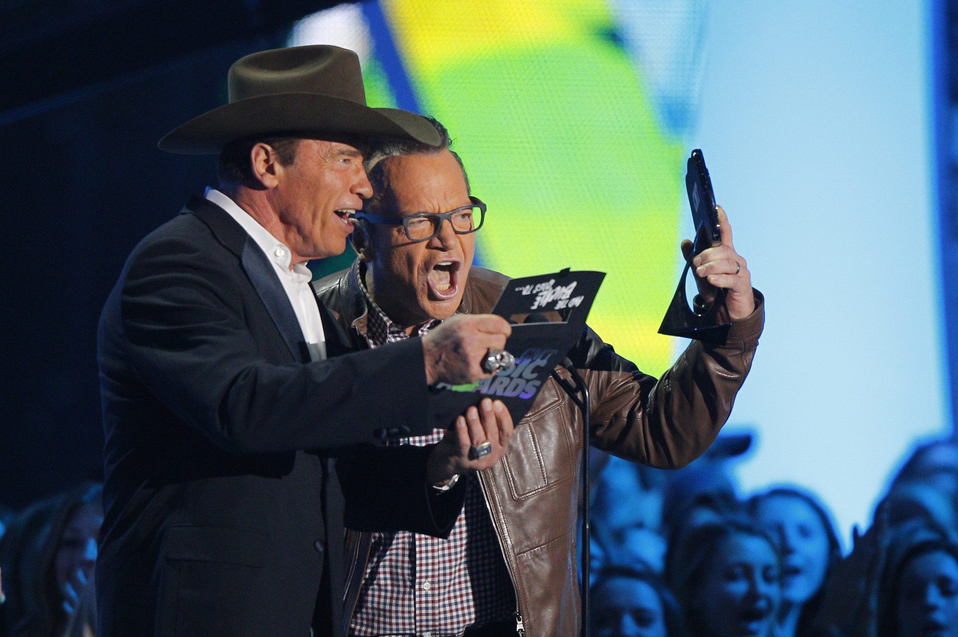 Tom Arnold, right, and Arnold Schwarzenegger present the award for video of the yea rat the CMT Music Awards at Bridgestone Arena on Wednesday, June 10, 2015, in Nashville, Tenn. (Photo by Wade Payne/Invision/AP)
