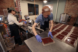 In this April 6, 2015, photo, Marta Crebilo, left, and Jason Thompson prepare chocolate molds at Olive and Sinclair Chocolate in the East Nashville area of Nashville, Tenn. The East Nashville neighborhood houses an eclectic collection of restaurants, bars, coffee shops, bakeries and stores, mixed into a residential area of 1950s and 1960s homes. (AP Photo/Mark Humphrey)