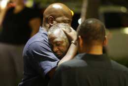 Worshippers embrace following a group prayer across the street from the scene of a shooting Wednesday, June 17, 2015, in Charleston, S.C. (AP Photo/David Goldman)