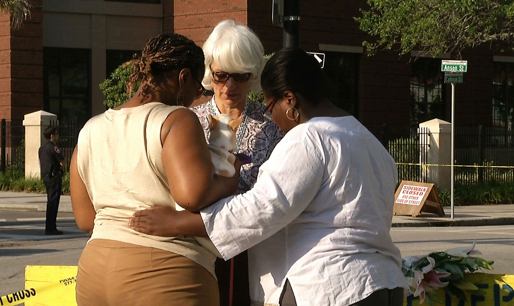  In this image taken from video on Thursday, June 18, 2015, Tarsha Moseley, left, Martha Watson, and Toby Smith pray at a makeshift memorial near Emanuel AME Church in Charleston, S.C. A white man opened fire during a prayer meeting inside the historic black church Wednesday night, killing several people. The shooter remained at large Thursday morning. (AP Photo/Alex Sanz)
