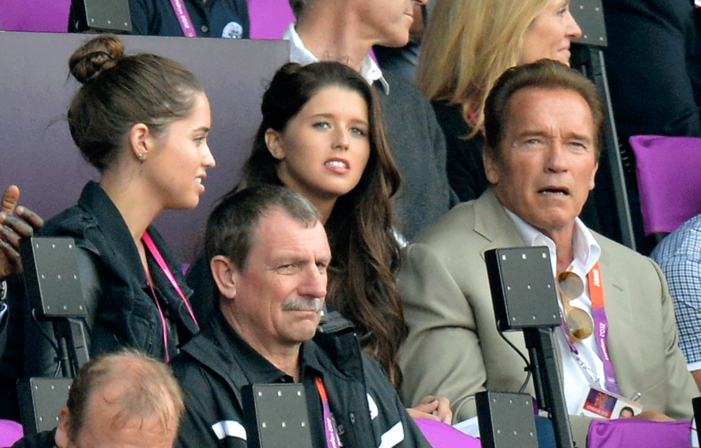 Arnold Schwarzenegger, right, sits with his daughters Christina, left, and Katherine, center, while attending the last evening session of athletics in the Olympic Stadium at the 2012 Summer Olympics, in London, Saturday, Aug. 11, 2012. (AP Photo/Martin Meissner)