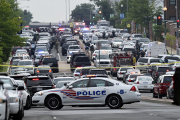 Police vehicles are seen near the Washington Navy Yard in Washington, Thursday, July 2, 2015. A lockdown is underway on the entire Washington Navy Yard campus after a report of shots fired.  (AP Photo/Susan Walsh)
