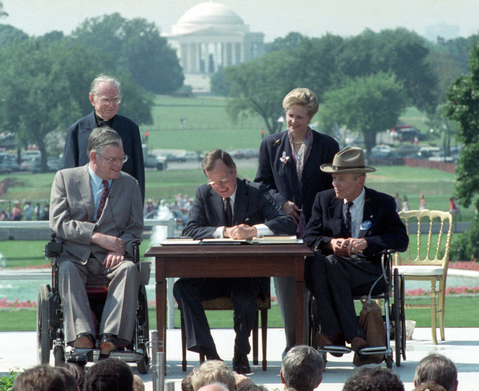 FILE - In this July 26, 1990 file photo, President George H. W. Bush signs the Americans with Disabilities Act during a ceremony on the South Lawn of the White House. Joining the president are, from left, Evan Kemp, chairman of the Equal Opportunity Employment Commission; Rev. Harold Wilke; Sandra Parrino, chairman of the National Council on Disability, and Justin Dart, chairman of The President's Council on Disabilities. TheAmericans with Disabilities Act, which was signed into law 25 years ago, on July 26, 1990.  (AP Photo/Barry Thumma)