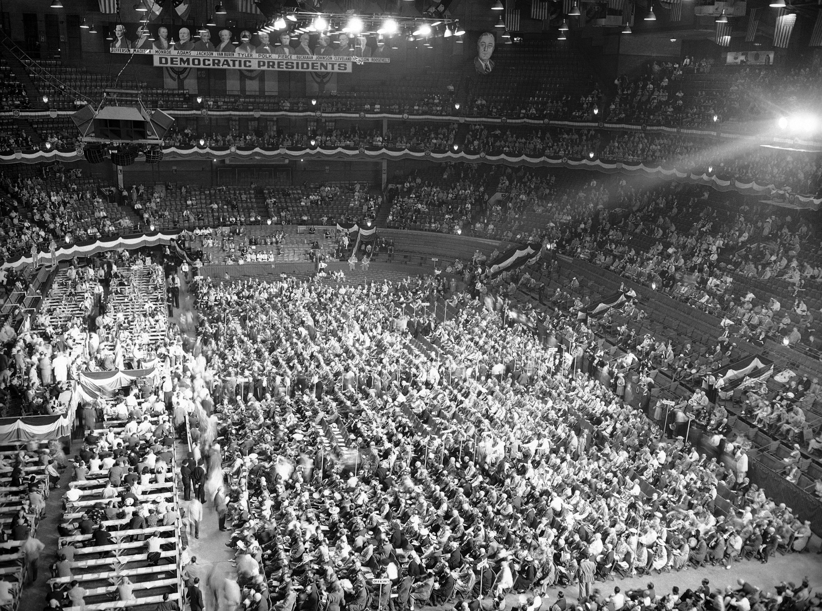 The first session of the Democratic National Convention was held in Chicago stadium on July 19, 1944. Speakers platform and press sections are at left, delegates sit in center floor section, and visitors and guests occupy top sections. Posters of Democratic presidents hang about top of convention hall (background). (AP Photo)
