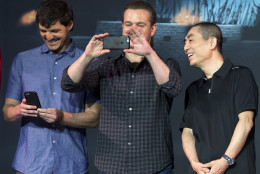 Director Zhang Yimou, right, looks at actor Matt Damon, center, using a mobile phone to take picture of the journalists next to actor Pedro Pascal, second from right, during a press conference for their latest movie The Great Wall held at a hotel in Beijing, China, Thursday, July 2, 2015. (AP Photo/Andy Wong)