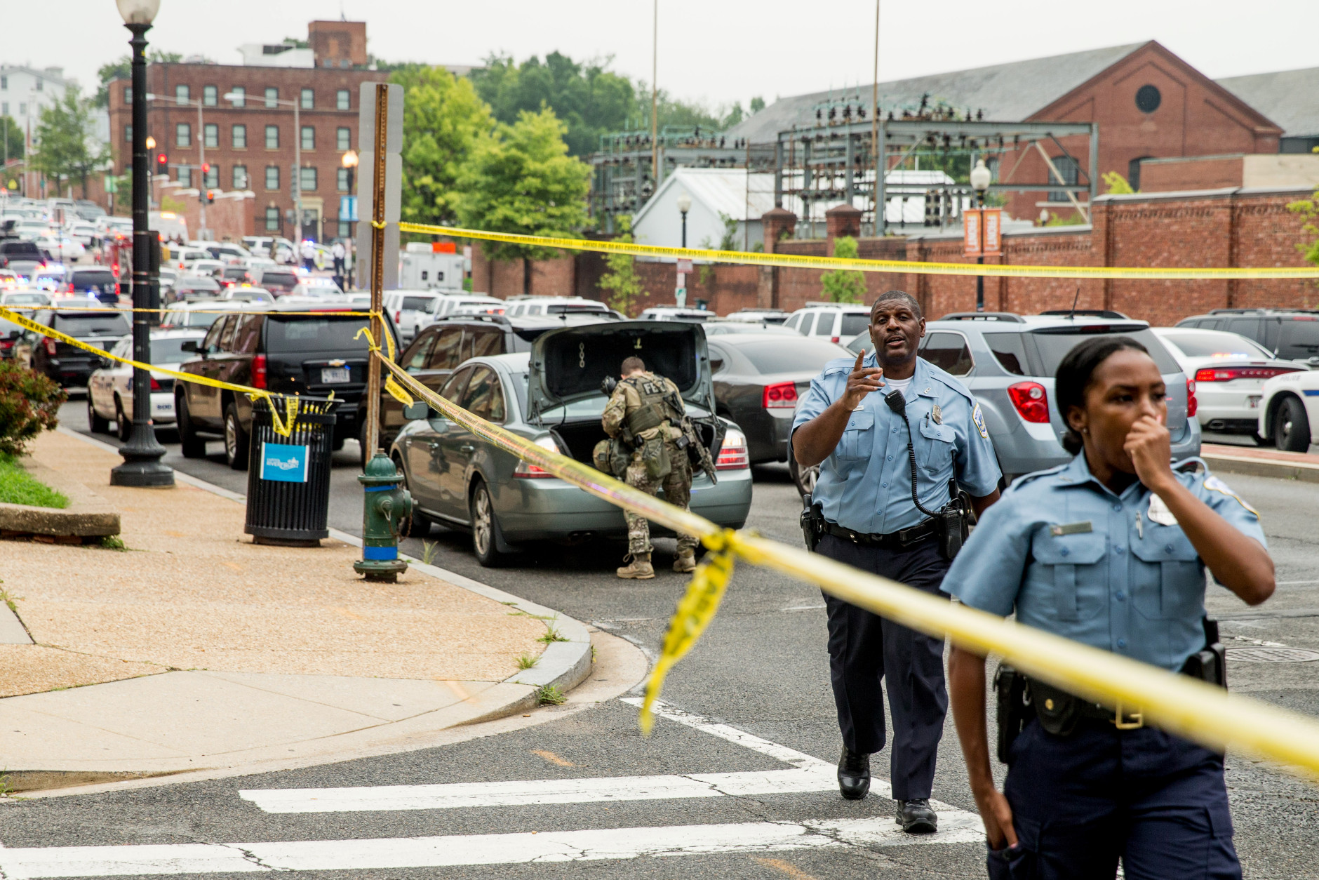 A large police presence gathers along M St. in Southeast Washington, Thursday, July 2, 2015. The Washington Navy Yard was on lockdown Thursday morning after reports of gunshots, but a senior federal law enforcement official says there has been no confirmed report of any shooting. (AP Photo/Andrew Harnik)
