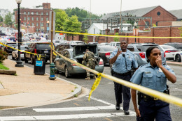 A large police presence gathers along M St. in Southeast Washington, Thursday, July 2, 2015. The Washington Navy Yard was on lockdown Thursday morning after reports of gunshots, but a senior federal law enforcement official says there has been no confirmed report of any shooting. (AP Photo/Andrew Harnik)