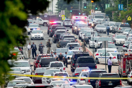 A large police presence gathers along M St. Southeast near the Navy Yard in Washington, Thursday, July 2, 2015, after an official said shots were reported in a building on the Washington Navy yard campus.  (AP Photo/Andrew Harnik)