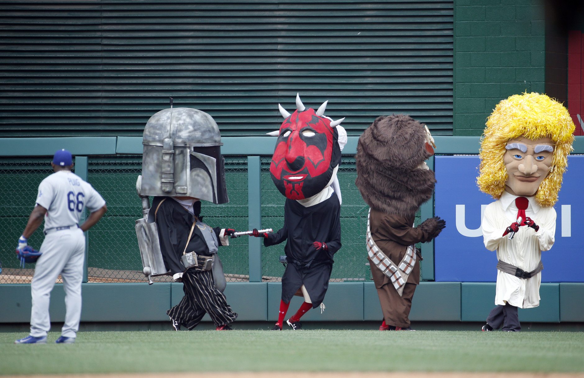 Los Angeles Dodgers right fielder Yasiel Puig (66) watches the Washington Nationals mascots the "Racing President," race as they are dressed up as Star Wars characters on Star Wars day during a baseball game at Nationals Park, Sunday, July 19, 2015, in Washington. (AP Photo/Alex Brandon)