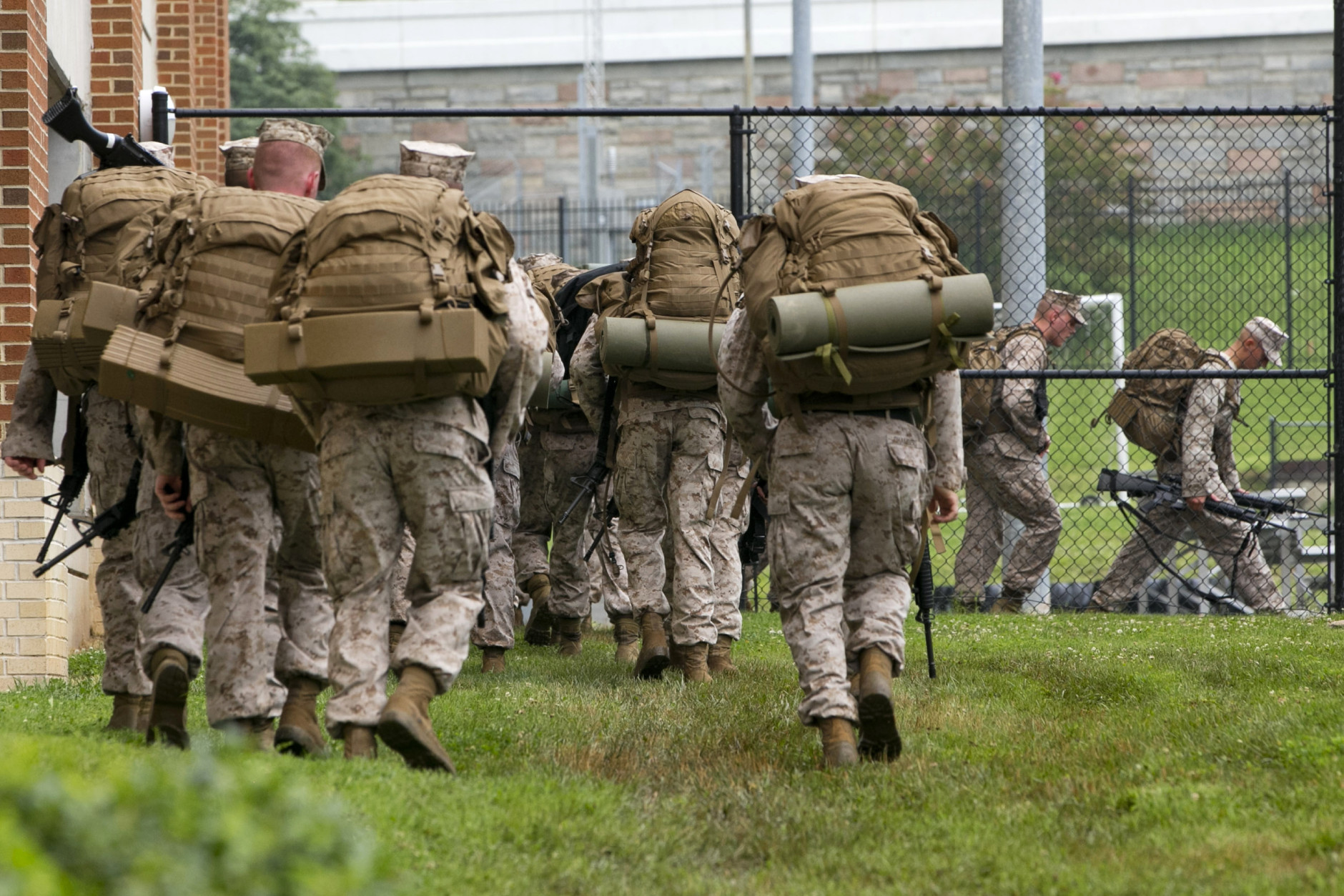 Troops move carrying guns walk at the Navy Yard in Washington, Thursday, July 2, 2015. A lockdown is underway on the entire Washington Navy Yard campus after a report of shots fired. (AP Photo/Jacquelyn Martin)