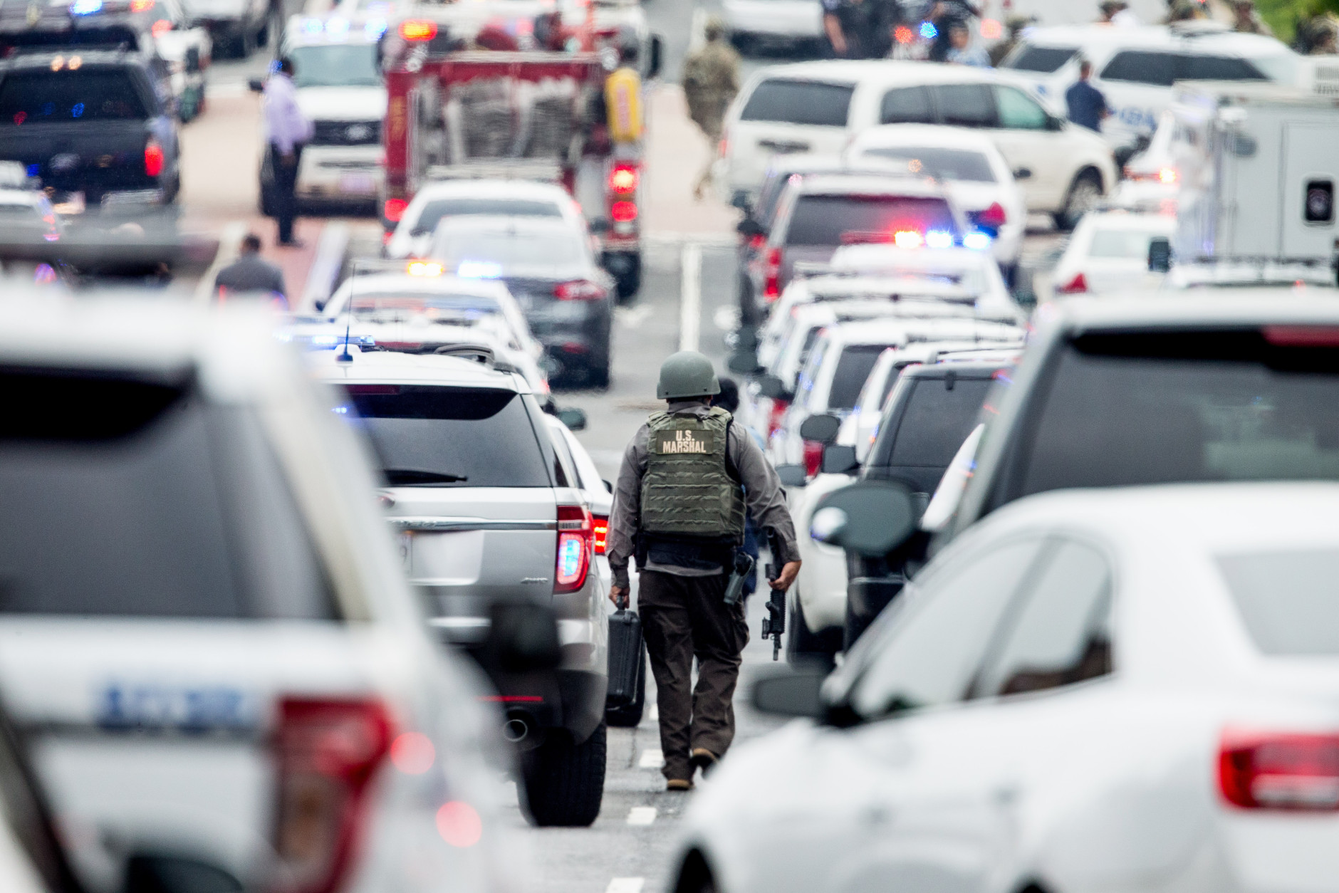 A large police presence gathers along M St. in Southeast Washington, Thursday, July 2, 2015, after an official said shots have been reported in a building on the Washington Navy Yard campus.  (AP Photo/Andrew Harnik)