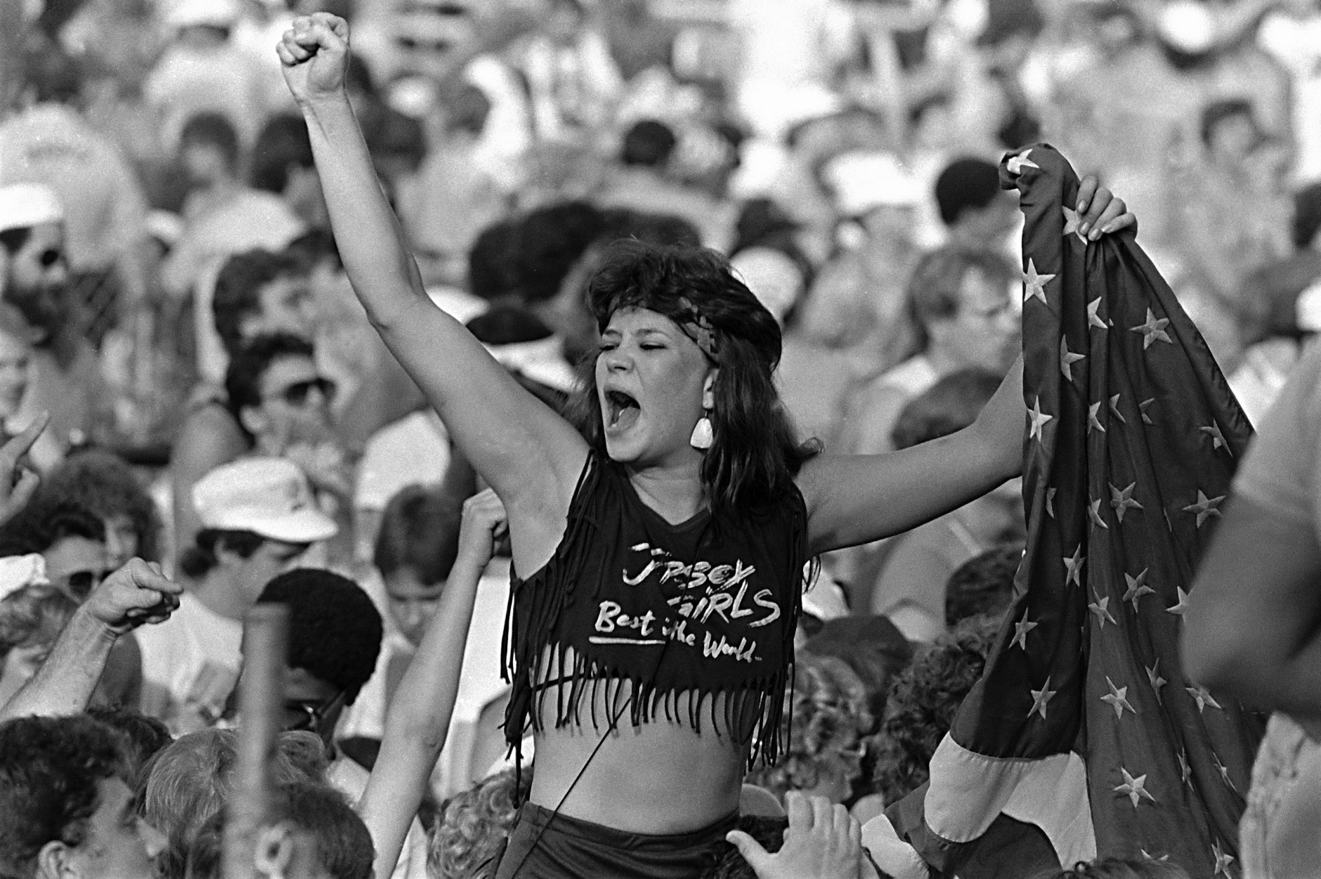 An unidentified fan, sporting a 'Jersey Girls Best in the World' t-shirt, cheers before the start of the Live Aid concert at Philadelphia's JFK Stadium, Saturday, July 13, 1985.  (AP Photo/Rusty Kennedy)