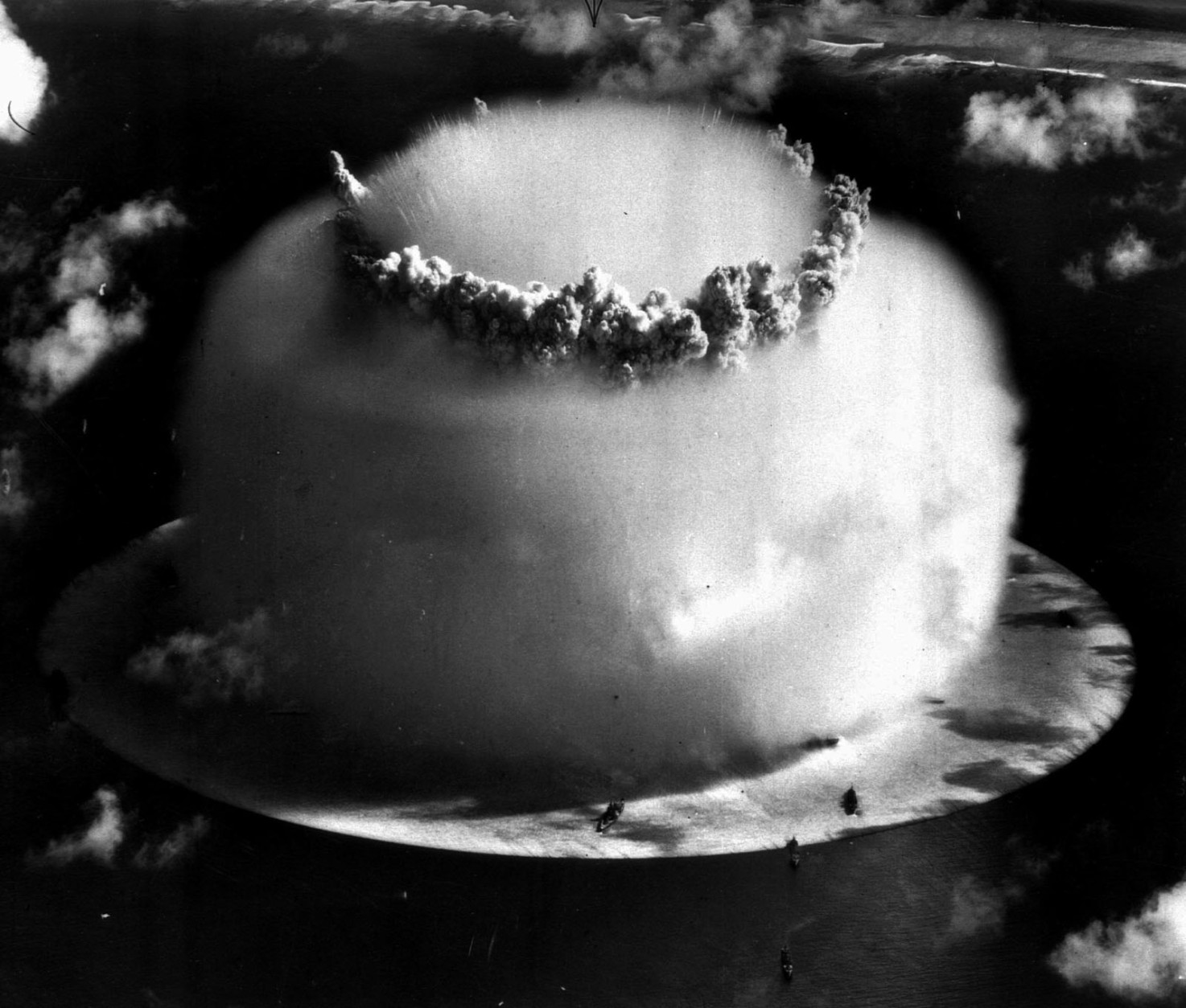 FOR USE WITH FEATURE PACKAGE FOR MONDAY, JULY 15--FILE--A huge mushroom cloud rises above Bikini atoll in the Marshall Islands July 25, 1946 following an atomic test blast, part of the U.S. military's "Operation Crossroads." The dark spots in foreground are ships that were placed near the blast site to test what an atom bomb would do to a fleet of warships. (AP Photo/file)