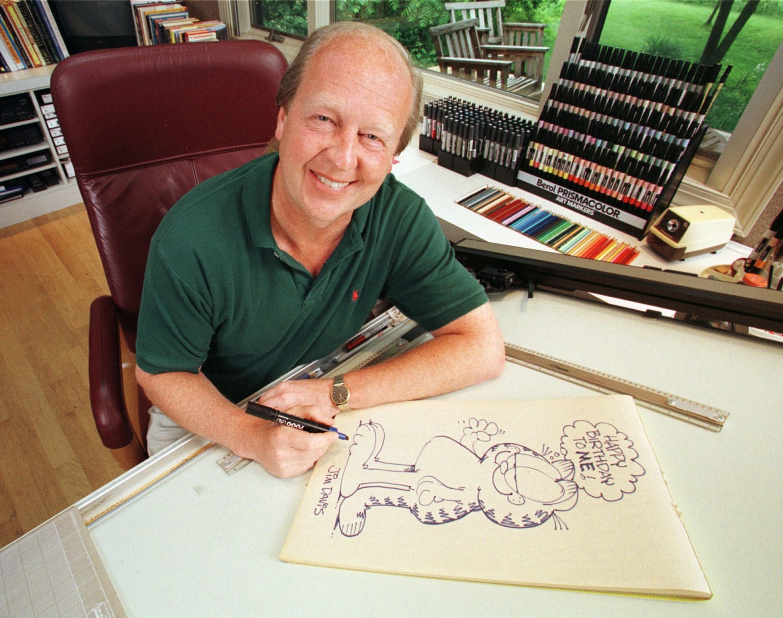 FILE - In this June 9, 1998 file photo, Garfield creator Jim Davis pauses after drawing the cartoon character in his Muncie, Ind., office. Davis apologized Thursday, Nov. 11, 2010, for a Garfield strip that some veterans may have found offensive. (AP Photo/Michael Conroy, File)