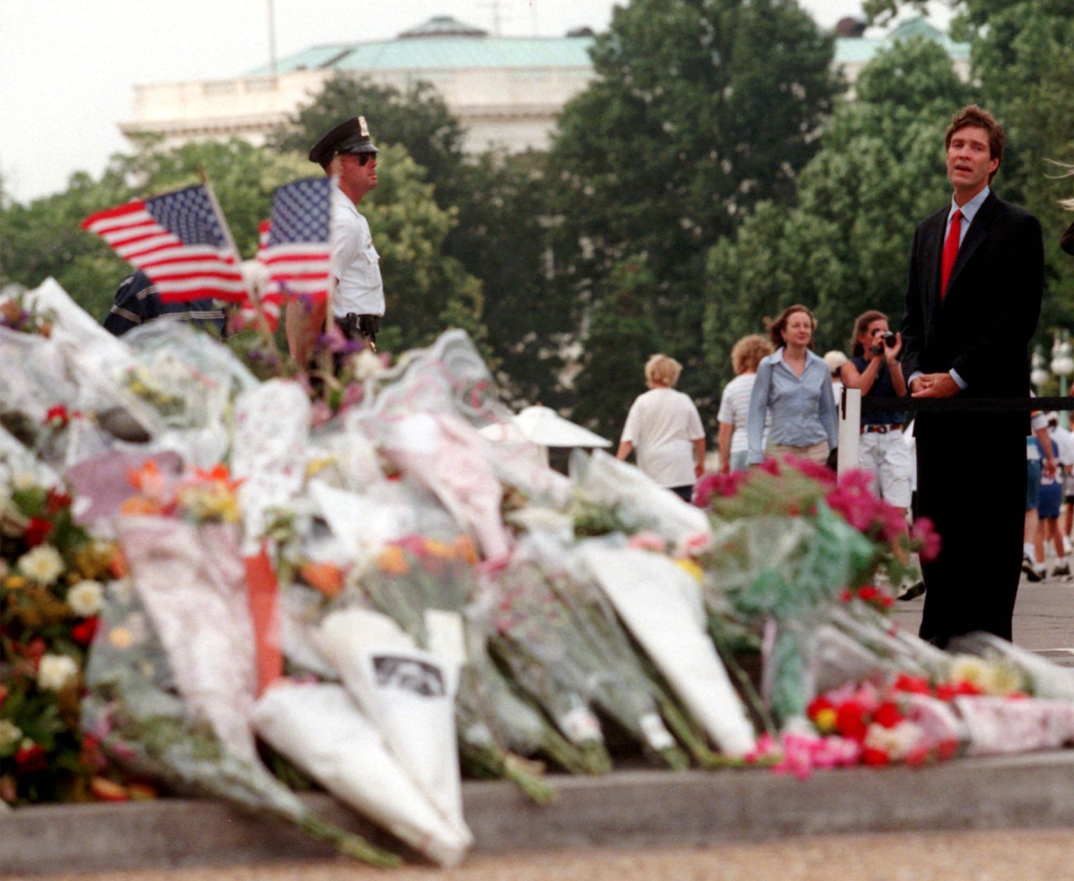 On this date in 1998, a gunman burst into the U.S. Capitol, killing two police officers before being shot and captured. In this image, Sen. Bill Frist, R-Tenn. pauses at flowers on the steps of the Capitol on July 27, 1998. Frist, a heart surgeon, is credited with saving the suspect, Russell Eugene Weston Jr.'s life. (AP Photo/Khue Bui)