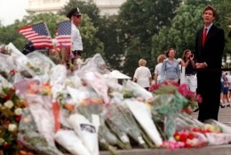 On this date in 1998, a gunman burst into the U.S. Capitol, killing two police officers before being shot and captured. In this image, Sen. Bill Frist, R-Tenn. pauses at flowers on the steps of the Capitol on July 27, 1998. Frist, a heart surgeon, is credited with saving the suspect, Russell Eugene Weston Jr.'s life. (AP Photo/Khue Bui)