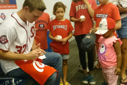 Washington Nationals starting pitcher Stephen Strasburg  signs autographs for young fans at Anacostia Library in Washington, D.C., on Saturday,  July 18, 2015. ( Dennis J. Foley/WTOP)