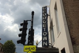 The Georgetown Theater's neon sign, which had been taken down for restoration, was reinstalled Wednesday in its familiar place above Wisconsin Avenue. (WTOP/Michelle Basch)