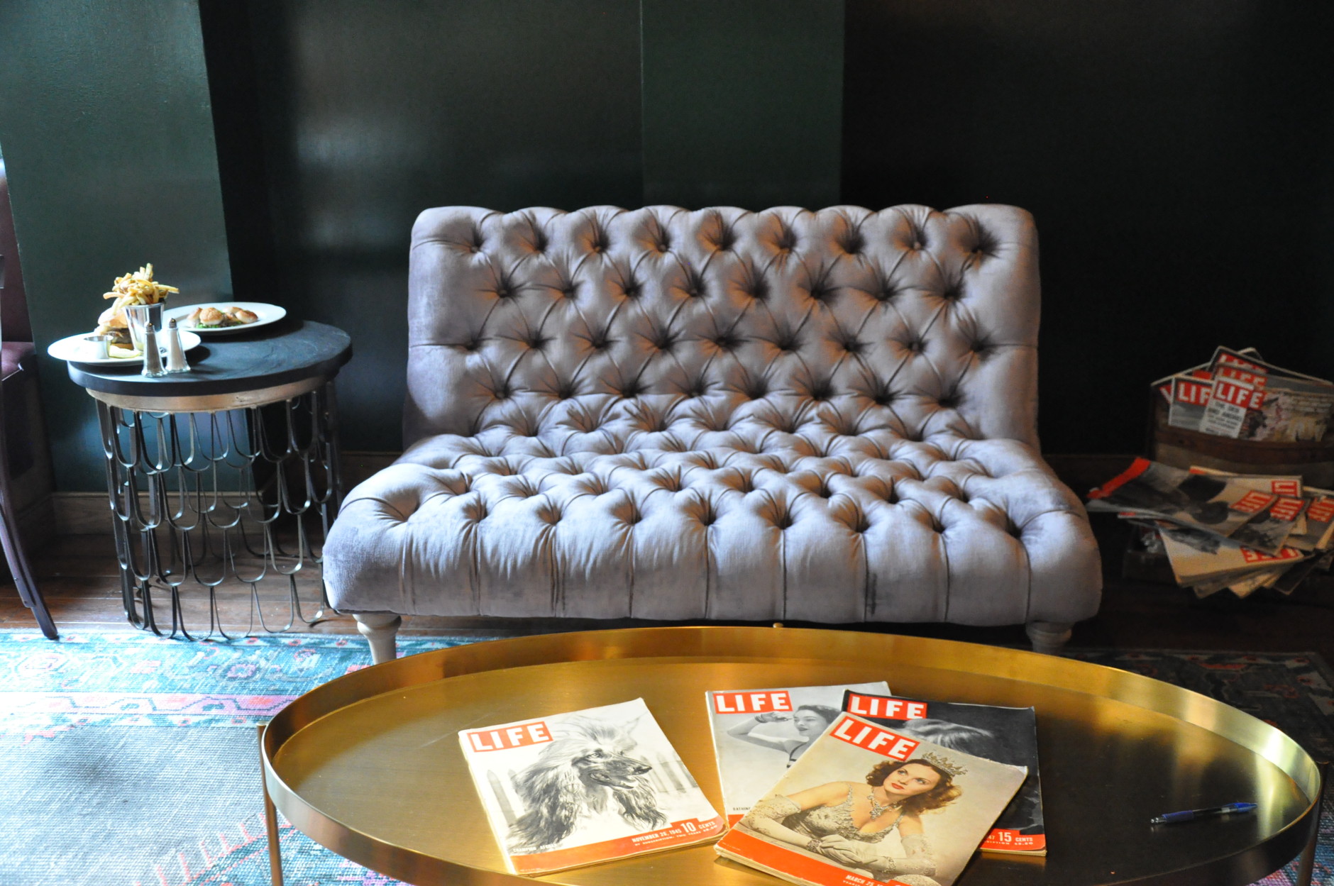 Vintage Life magazines decorate a gold coffee table in the lounge. (WTOP/Rachel Nania)