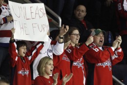Fans cheer on the Washington Capitals during the third period of an NHL hockey game against the Chicago Blackhawks at the Verizon Center in Washington, on Sunday, March 13, 2011. The Capitals won 4-3 for their eighth straight victory. (AP Photo/Jacquelyn Martin)