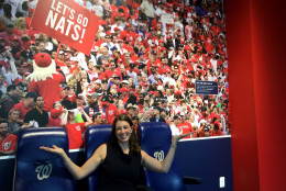 Frugal fans accustomed to the "cheap seats" can try out "premium seats" like Jennifer Giglio, Nationals vice president of communications, demonstrates at the Newseum's new exhibit featuring the first 10 years of Nationals baseball. (WTOP/Kristi King)