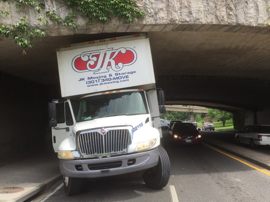 The moving truck was traveling southbound on the Rock Creek Parkway around 11 a.m. on Wednesday when it collided with the K Street/Whitehurst Freeway overpass. The arched overpass, at its lowest point, is 12 feet high.  (WTOP/Dave Dildine)