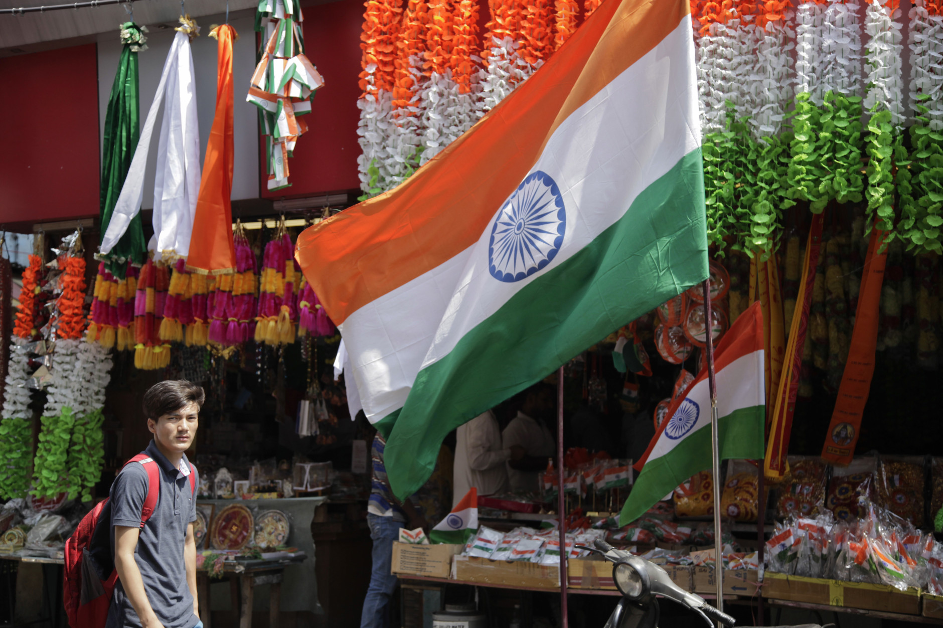 A shopkeeper displays Indian flags at the entrance of his shop in Jammu, India, Saturday, Aug.13, 2016. Shops across the country are laden with flags and other festive paraphernalia as India prepares to celebrate its Independence Day on Aug. 15. (AP Photo/Channi Anand)