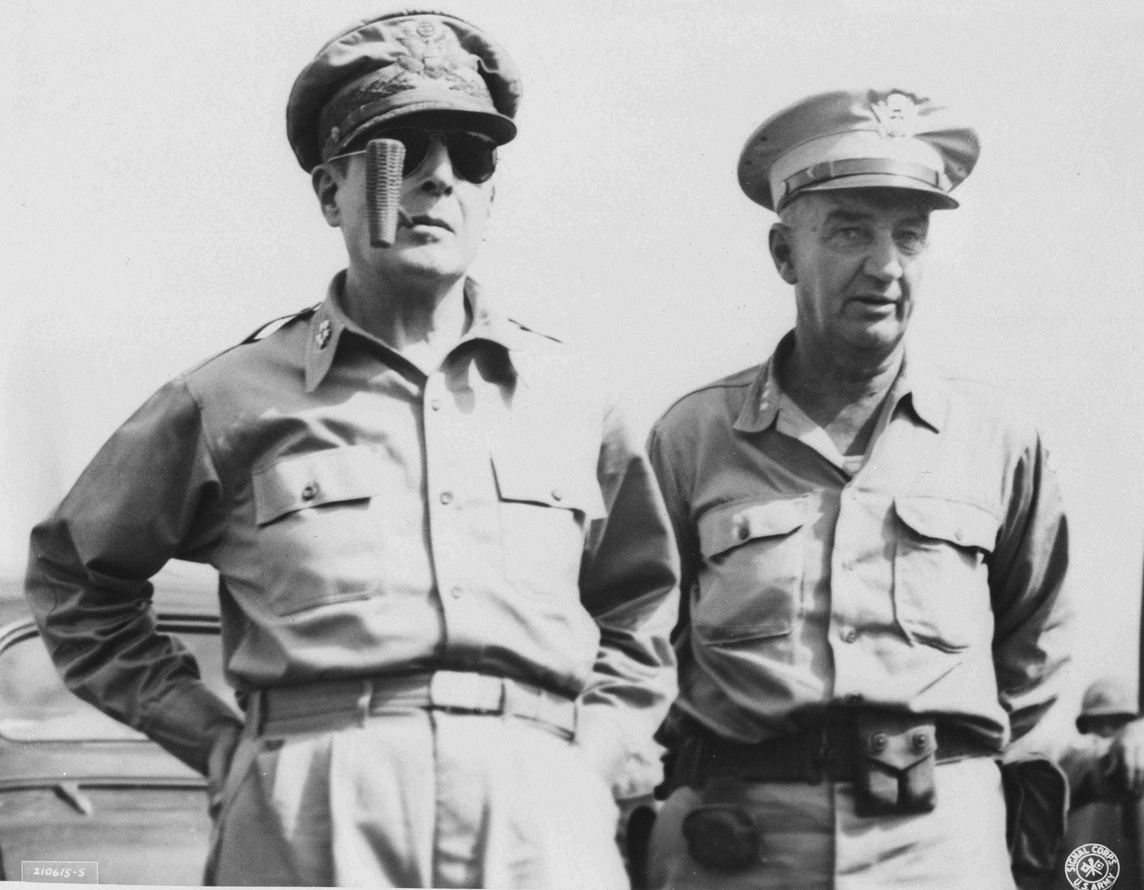 Gen. Douglas MacArthur, left, enjoying his fames corncob pipe, meets Lt. Gen. Robert L. Eichelberger, commanding General eighth army, right, after General MacArthur's arrival Aug. 30, 1945 at Atsugi Airport near Tokyo.