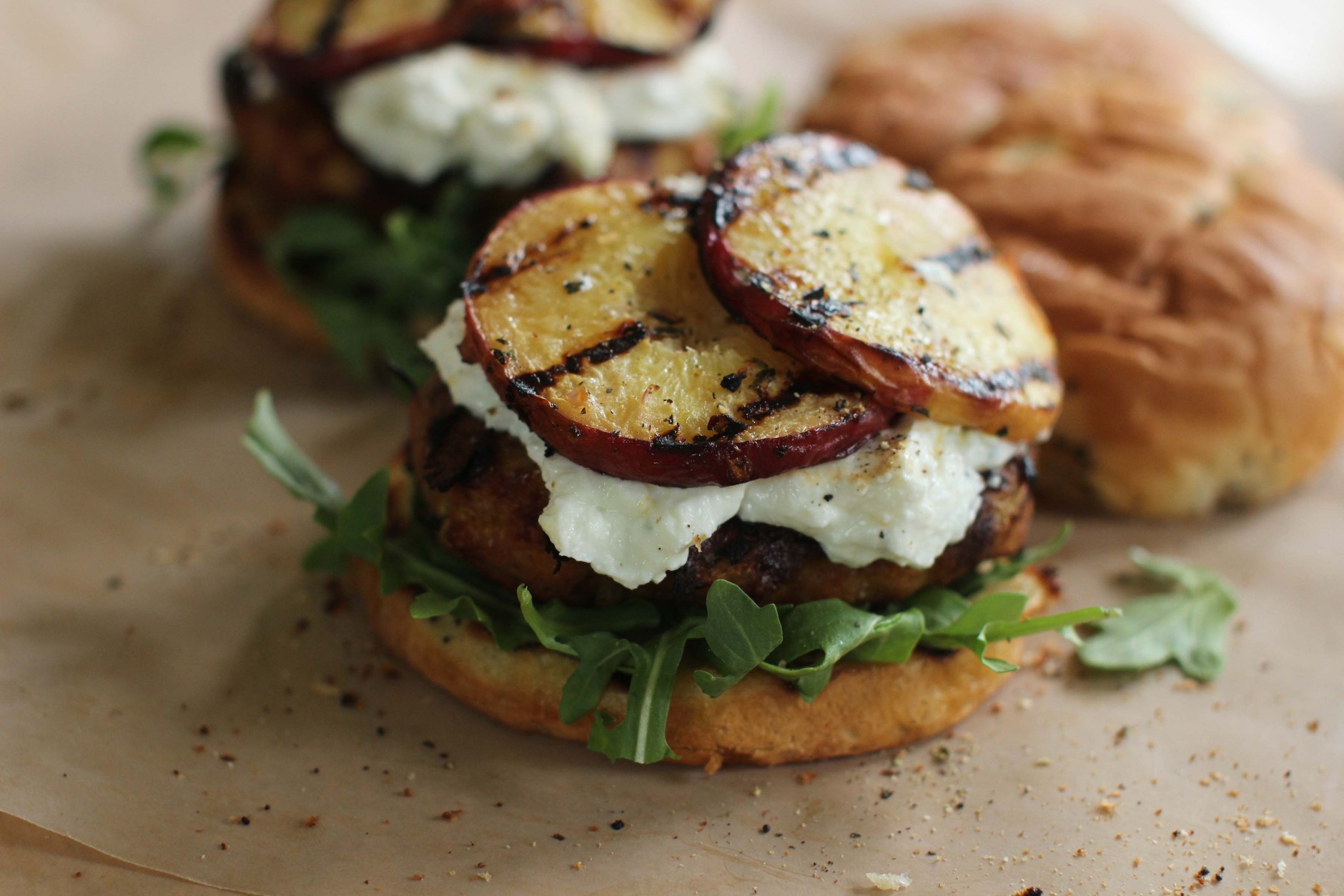 This June 1, 2015 photo shows turkey burgers with goat cheese and grilled peaches in Concord, N.H. (AP Photo/Matthew Mead