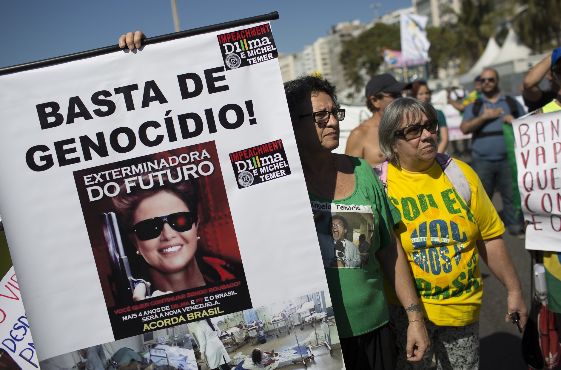 A woman holds a sign that reads in Portuguese "Enough genocide!" and "Exterminator of the Future" with an image depicting Brazil's President Dilma Rousseff holding a gun, during a protest demanding the her impeachment in Rio de Janeiro, Brazil, Sunday, Aug. 16, 2015. Demonstrators are taking to the streets across Brazil for a day of nationwide anti-government protests. President Rousseff's second term in office has been shaken by a snowballing corruption scandal involving politicians from her Workers Party, as well as a spluttering economy, spiraling currency and rising inflation, making her popularity ratings fall to historic lows. (AP Photo/Leo Correa)