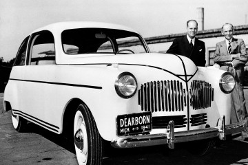 Henry Ford pictured with one of his cars.