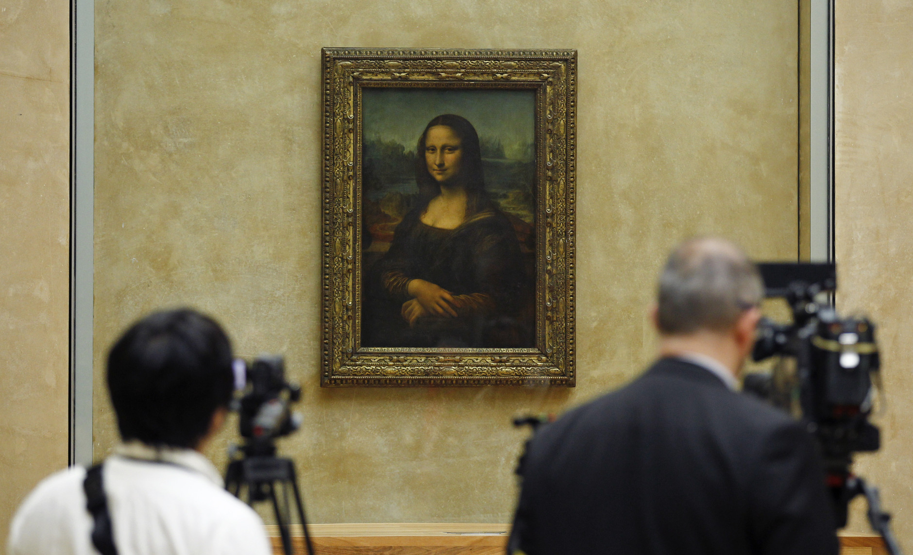 Members of the media are gathered next to the Mona Lisa, during an event to unveil the new lighting of Leonardo da Vinci's painting Mona Lisa, also known as La Joconde, at the Louvre museum in Paris, Tuesday June 4, 2013. Mona Lisa is now illuminated by LED lighting. The lighting had to meet various technical specifications, but also meet the more subjective and aesthetic requirements of the museum Director and Frances Historical Monuments Committee.(AP Photo/Remy de la Mauviniere)