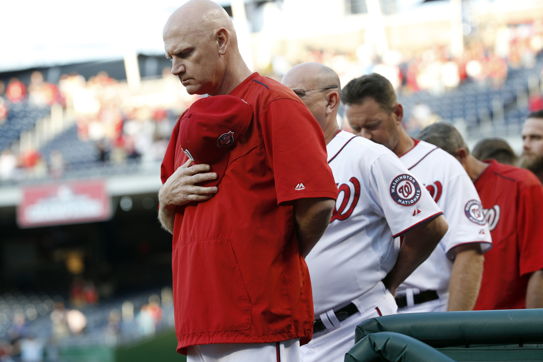 Washington Nationals manager Matt Williams, left, and other members of the Nationals observe a moment of silence before a baseball game against the San Diego Padres at Nationals Park in Washington on Wednesday, Aug. 26, 2015, for those killed and injured in the on-air shooting in Moneta, Va. (AP Photo/Alex Brandon)