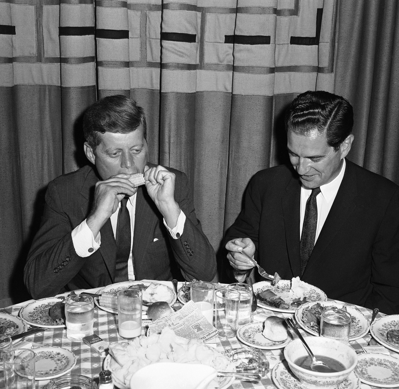 U.S. Sen. John Kennedy, the Democratic presidential nominee, bites into some Iowa sweet corn at a home-style dinner in Des Moines, August 21, 1960 in Illinois. He and his running mate, Sen. Lyndon Johnson were in this city of the farm belt to tell how they would improve the agriculture situation. (AP Photo)