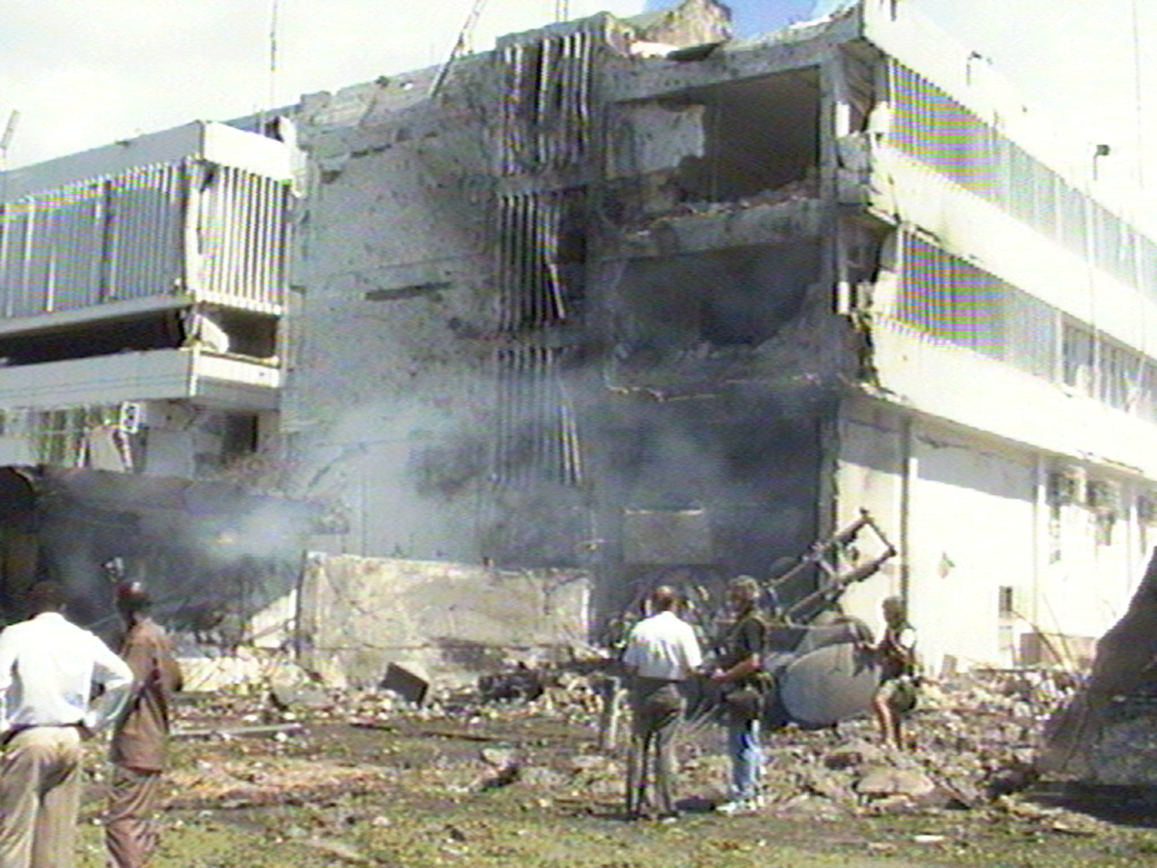 Smoke rises from the U.S. Embassy in Dar es Salaam, Tanzania, in this frame grabe from television, after a suspected car bomb exploded outside it Friday Aug. 7 1998.  Reports said that at least nine people were killed and 16 were injured in the blast. There was also an explosion outside the U.S. Embassy in Nairobi, Kenya, at the same time, causing extensive damage and killing more than people. (AP Photo / APTV)  TANZANIA OUT - TV OUT