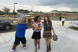 Freshmen Haily and Tate get a greeting from the mascot as they arrive for the first day of classes at the new Riverside High School. (WTOP/Kristi King)