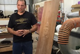 Lawrence Wroten shows off the design for the back of the chair Pope Francis will use for the outdoor mass. (WTOP/Andrew Mollenbeck)