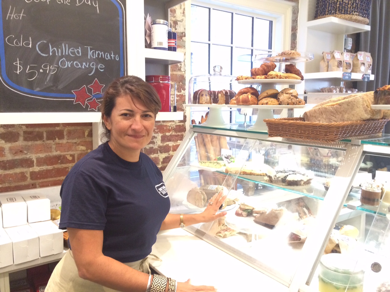 Ximena Rozo works the front counter at Dog Tag Bakery. It’s through kneading dough that Rozo says she has learned the best ways make dough from her furniture business. (WTOP/Rachel Nania)
