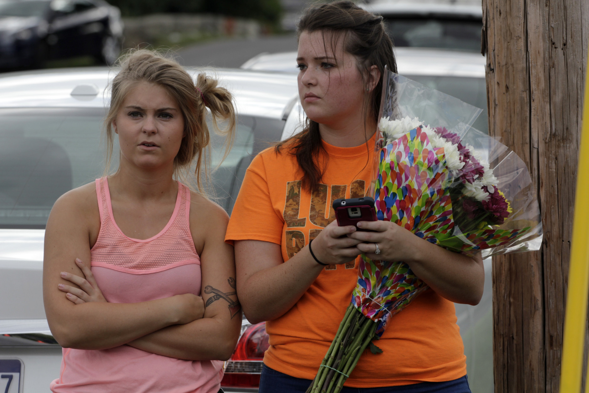 ROANOKE, VA - AUGUST 26: Madalyn Hartberger (L) and Rachel Ostrom bring flowers for the two journalists that were killed this morning during a live broadcast on August 26, 2015 in Roanoke, Virginia. Two employees of WDBJ TV were killed this morning during a live broadcast at Bridgewater Plaza on Smith Mountain Lake. The victims have been identified as reporter Alison Parker and cameraman Adam Ward. Parker, 24 and Ward, 27, worked for WDBJ in Roanoke, Virginia. The suspect, Vester Lee Flanigan, also known as Bryce Williams, died of a self-inflicted gunshot wound. (Photo by Jay Paul/Getty Images)