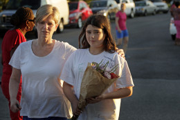 ROANOKE, VA - AUGUST 26: Lisa Bazzarre and her daughter Lauren Lasser, 12, bring flowers for the two journalists that were killed this morning during a live broadcast on August 26, 2015 in Roanoke, Virginia. Two employees of WDBJ TV were killed this morning during a live broadcast at Bridgewater Plaza on Smith Mountain Lake. The victims have been identified as reporter Alison Parker and cameraman Adam Ward. Parker, 24 and Ward, 27, worked for WDBJ in Roanoke, Virginia. The suspect, Vester Lee Flanigan, also known as Bryce Williams, died of a self-inflicted gunshot wound. (Photo by Jay Paul/Getty Images)