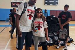 Rising sixth grader Heather Lee, of Stuart Hobson Middle School, D.C. poses for a photo with Wizards guard John Wall during a backpack giveaway event Saturday, Aug. 15, 2015. (Dick Uliano/WTOP)
