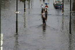 New Orleans residents walk through floodwaters that besiege the Crescent City on Tuesday, Aug. 30, 2005. Hurricane Katrina devastated the Louisiana and Mississippi coasts when it came ashore on Monday. (AP Photo/Bill Haber)