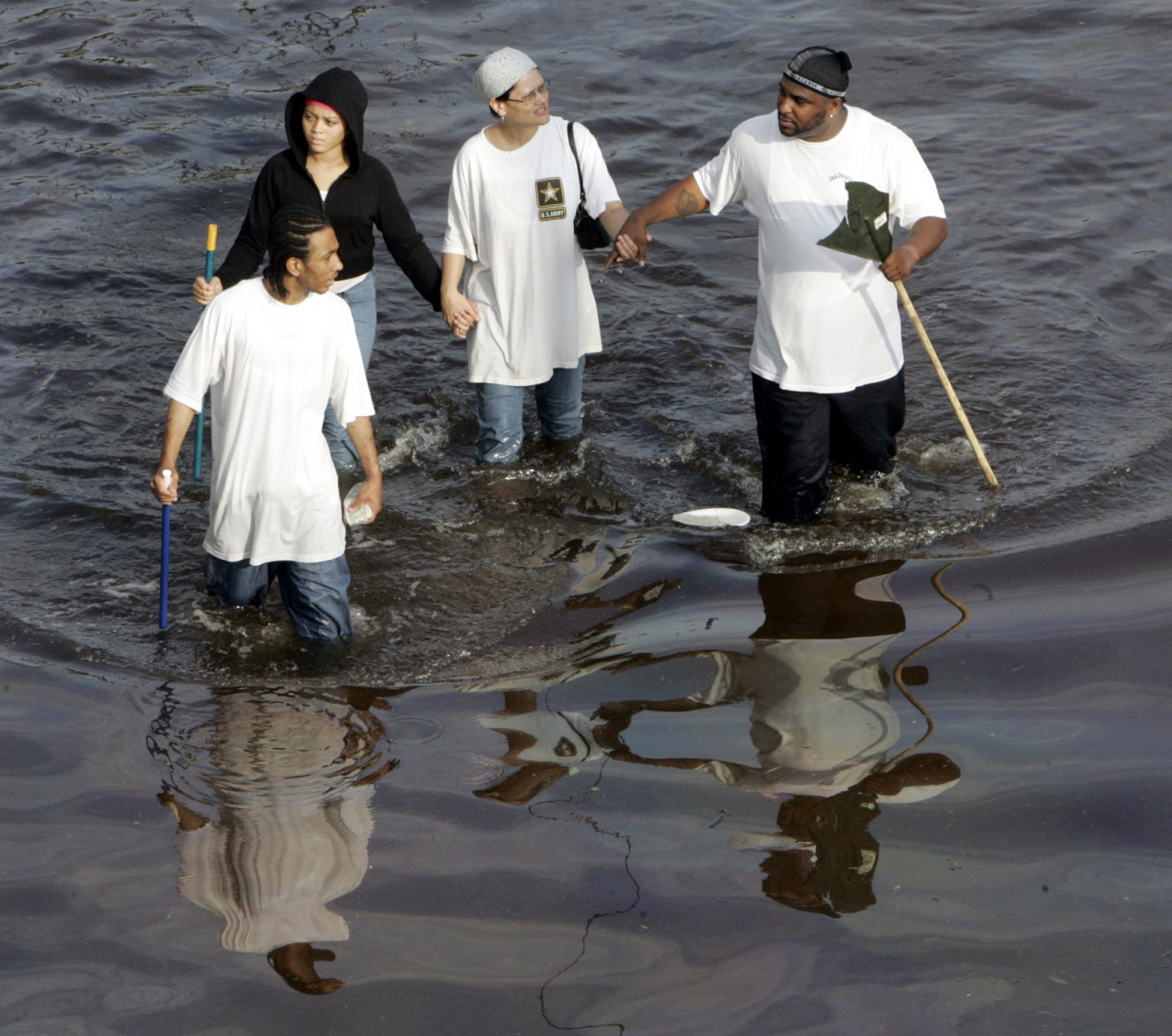 New Orleans residents walk through floodwaters that besiege the Crescent City on Tuesday, Aug. 30, 2005. Hurricane Katrina devastated the Louisiana and Mississippi coasts when it came ashore on Monday. (AP Photo/Bill Haber)