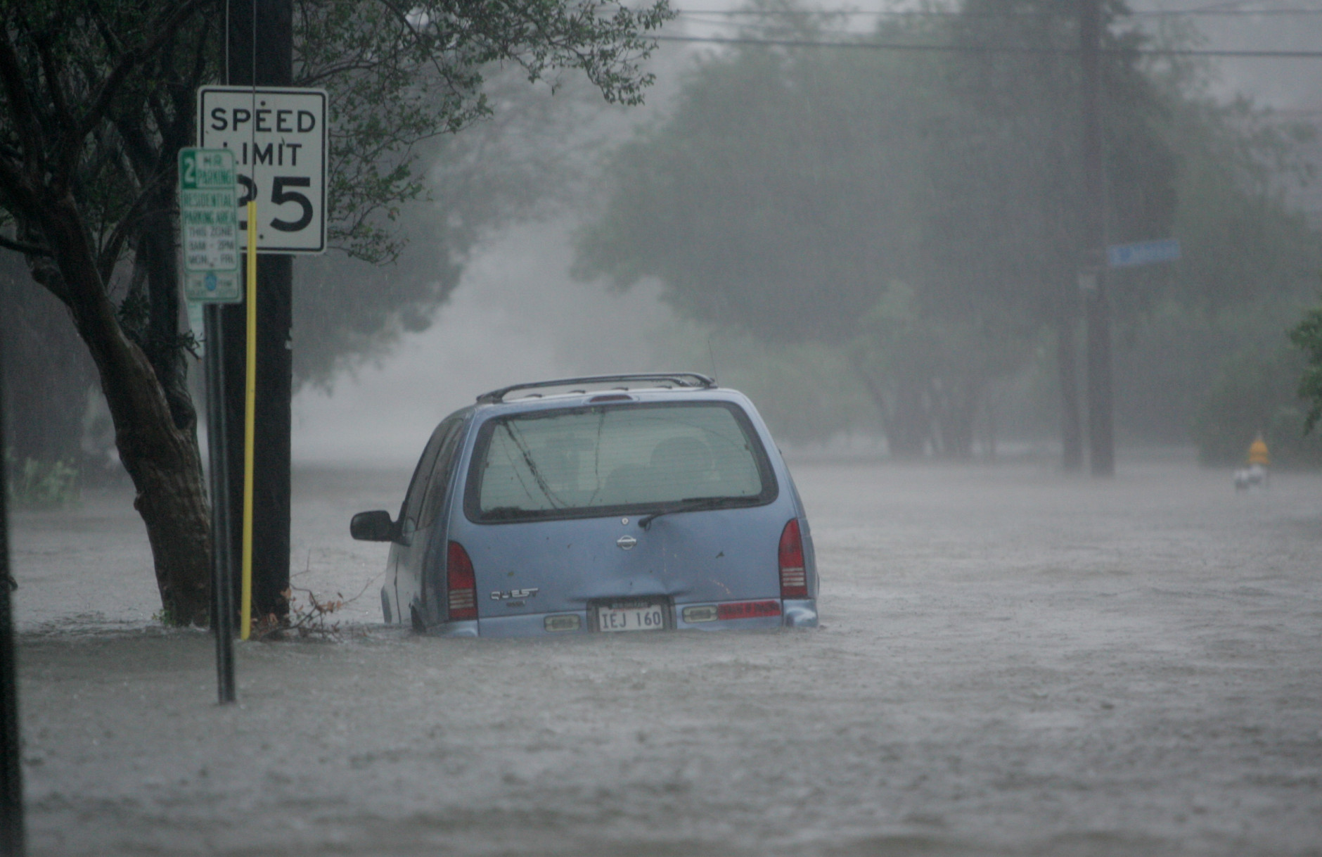 Floodwaters surround a car in uptown New Orleans early Monday, Aug. 29, 2005 as high winds and rain batter the Louisiana coast as Hurricane Katrina makes landfall. (AP Photo/Dave Martin)