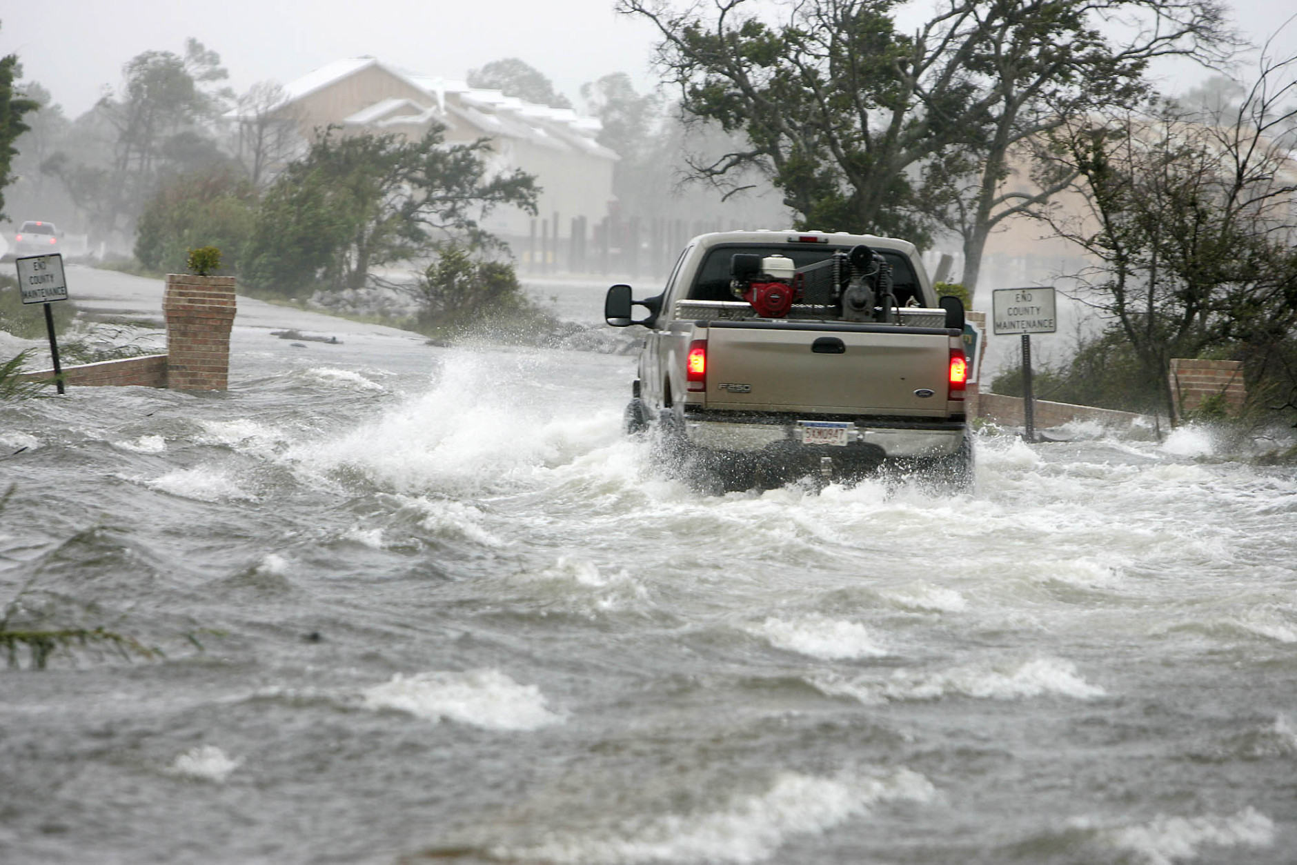 A vehicle makes its way through a flooded street from the overflowing  Grande Lagoon  in Pensacola, Fla., as Hurricane Katrina passes through the area, Monday, Aug. 29, 2005. (AP Photo/Peter Cosgrove)