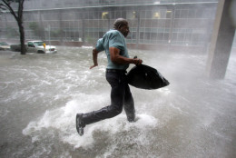 Arnold James tries to keep his feet as a strong gust nearly blows him over as he tries to make his way on foot to the Louisiana Superdome in New Orleans on Monday, Aug. 29, 2005.  The roof on James's home blew off, forcing him to seek shelter at the Superdome. (AP Photo/Dave Martin)